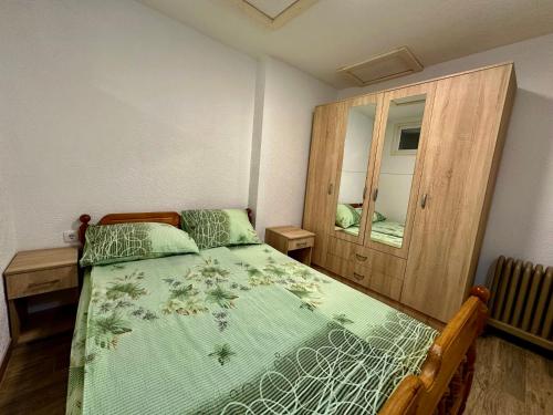 een slaapkamer met een bed en een houten kast bij Urban Apartmens 5 in Jošanička Banja