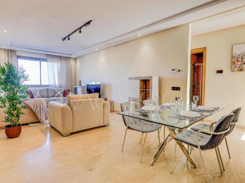 a living room with a glass table and chairs at Iris Agadir - Luxe - Piscine - 4 Px in Agadir
