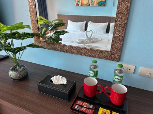 a table with a mirror and a tray with mugs at Mido Selected Resort Pool Hotel in Pattaya