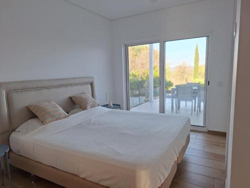 a bedroom with a bed and a balcony with a table at Casa Bravo in Querença