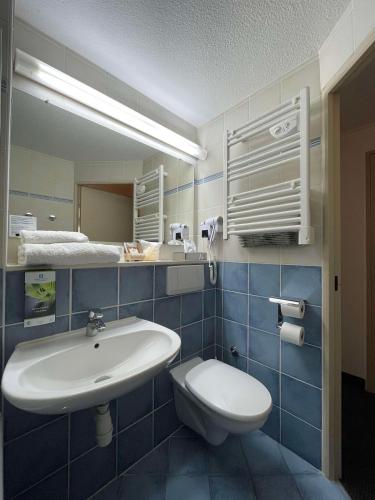 a bathroom with a sink and a toilet and a mirror at Sure Hotel by Best Western Limoges Sud in Feytiat