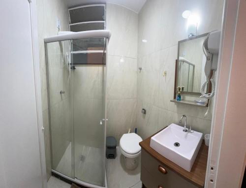 a bathroom with a shower and a toilet and a sink at Kitnet Petrópolis in Petrópolis