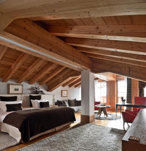 une chambre avec un grand lit et des plafonds en bois dans l'établissement Le Strato, à Courchevel