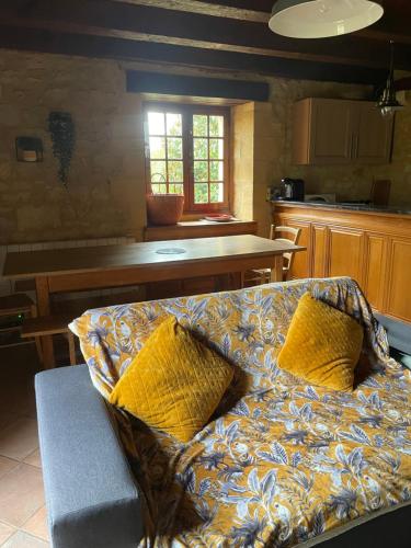 un canapé avec des oreillers jaunes assis dans une cuisine dans l'établissement Cozy maisonette de Domme, à Domme