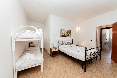 a bedroom with two bunk beds and a bathroom at Villa Mello in Torre Lapillo