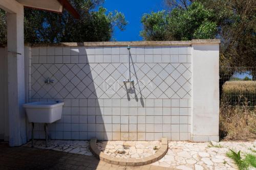 a bathroom with a sink and a toilet on a tiled wall at Villa Mello in Torre Lapillo