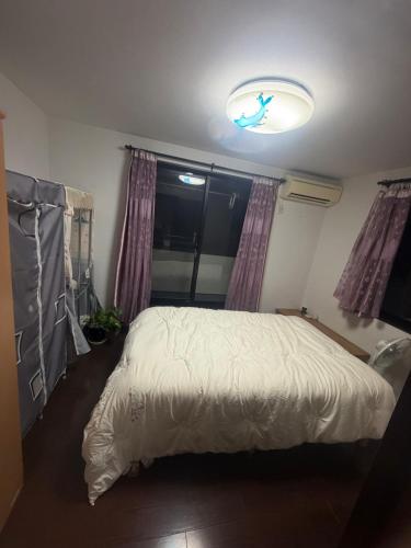 a bedroom with a white bed and a window at sakuraの家 in Tokyo