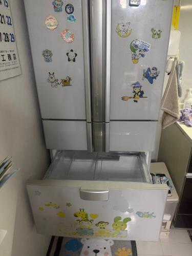 a refrigerator with stickers on it in a kitchen at sakuraの家 in Tokyo