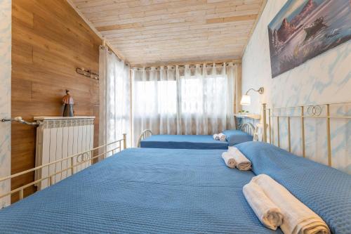 een slaapkamer met 2 bedden met blauwe lakens bij Villa Messapia in Torre dell'Orso