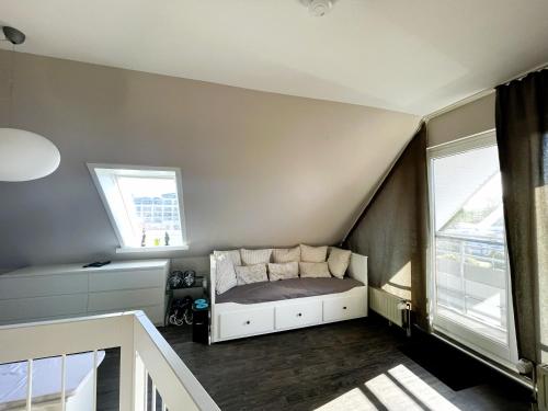 a small bedroom with a bed and two windows at Haus Seeburg Appartement 2.6 - strandnah in Scharbeutz