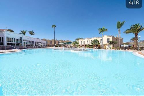 ein großer Swimmingpool in einem Resort mit Palmen in der Unterkunft Maspalomas Green Oasis 1404 in Maspalomas
