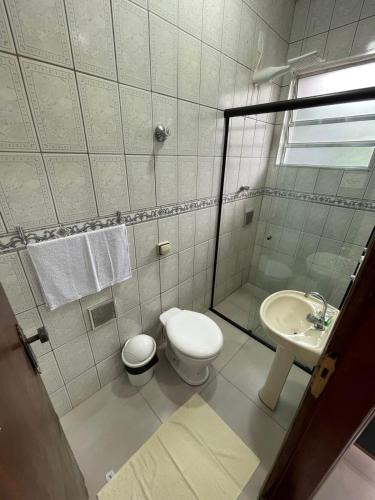 a bathroom with a toilet and a sink at Pousada das Flores in Aparecida