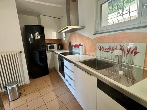 La cuisine est équipée d'un évier et d'un réfrigérateur noir. dans l'établissement Rovio Villa lake View & Relax, Lago di Lugano 4guests, à Lugano