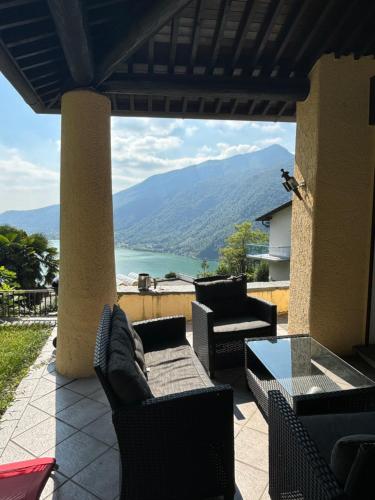 un patio avec des canapés et une vue sur une montagne dans l'établissement Rovio Villa lake View & Relax, Lago di Lugano 4guests, à Lugano