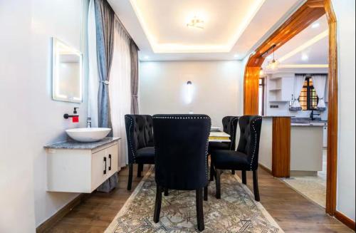 a dining room with a table and black chairs at Emerald Greens 3-Bedroom House in Thika