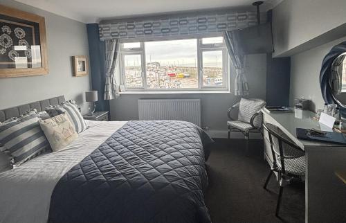 a bedroom with a bed and a desk and a window at Salt on the Harbour in Bridlington