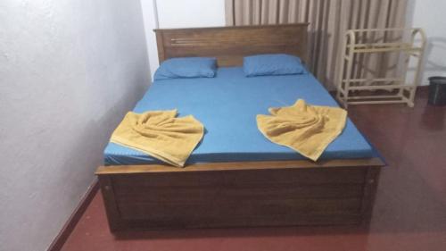 een bed met blauwe lakens en gele handdoeken erop bij Madura Resorts in Piliyandala