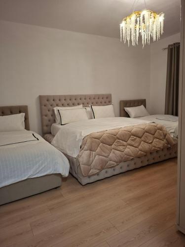 una camera da letto con due letti e un lampadario di Heart Apartment Tirana a Tirana