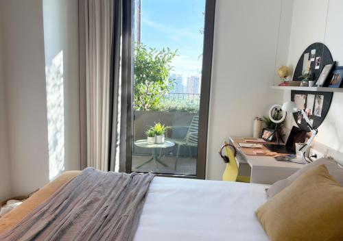 een slaapkamer met een bed en uitzicht op een balkon bij aparto Diagonal Suites in Esplugues de Llobregat
