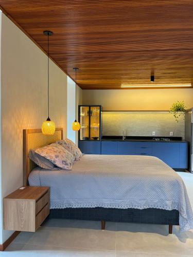 a bedroom with a large bed with a wooden ceiling at Recanto Gamboa in Garopaba