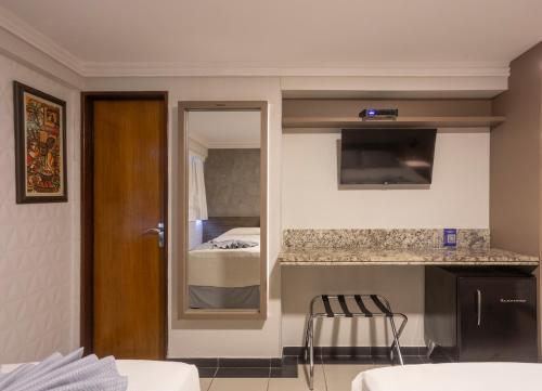une chambre d'hôtel avec une cuisine et une chambre dans l'établissement Atlântico Praia Hotel, à João Pessoa