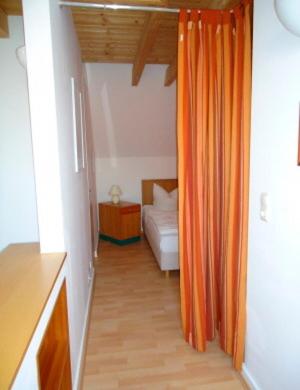 an orange curtain in a room with a bed at Ferienhaushälfte Fleesensee in Göhren-Lebbin