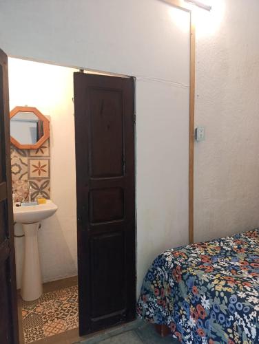 a bedroom with a bed and a sink and a door at Casa petirrojo - habitaciones en Pátzcuaro in Pátzcuaro
