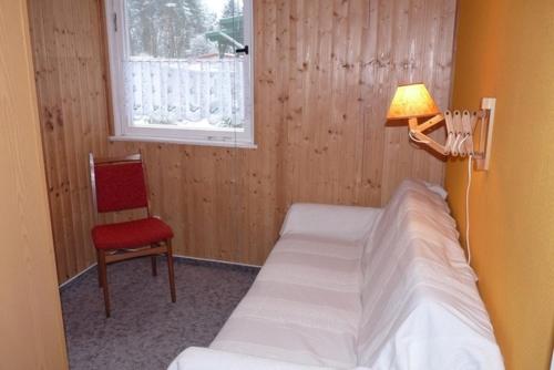 una camera con due letti e una lampada e una sedia di Ferienhaus nahe Stechlinsee a Neuglobsow