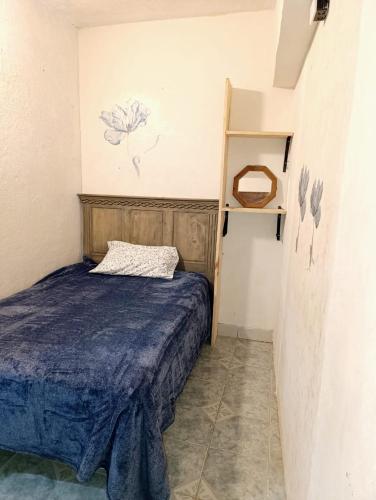 a small bedroom with a bed and a shelf at Casa petirrojo - habitaciones en Pátzcuaro in Pátzcuaro