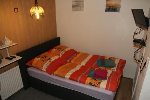 Bett mit farbenfroher Bettdecke in einem Zimmer in der Unterkunft Ferienhaus in Zechow in Köpernitz