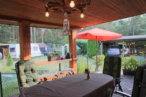 eine Terrasse mit Tisch und Sonnenschirm in der Unterkunft Ferienhaus in Zechow in Köpernitz