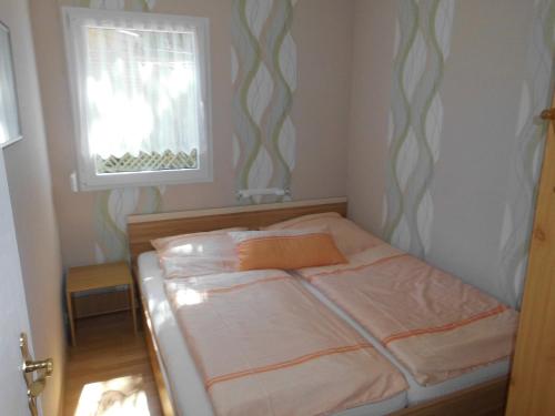 a bed in a small room with a window at Ferienbungalow Fleesensee in Malchow