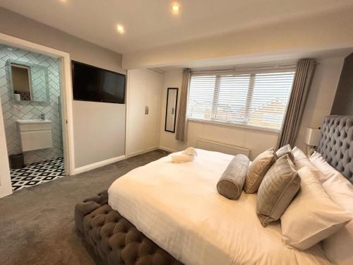 een slaapkamer met een groot bed met een groot raam bij Dalton House - Private Parking in Blackpool