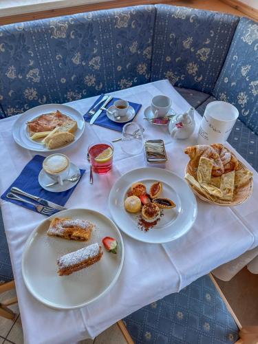 un tavolo con sopra piatti di cibo per la colazione di Hotel Alpe Bellaria a Candriai