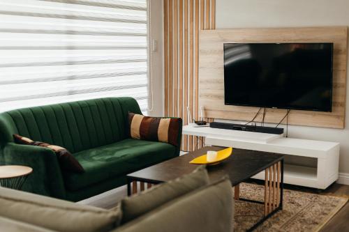 a living room with a green couch and a television at Disa Close 3 Cathkin Estates in Winterton