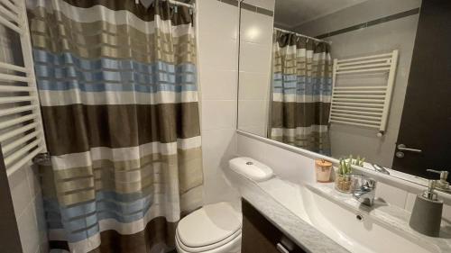 a bathroom with a toilet and a sink and a shower at Departamento Costa Pucón in El Cerrillo