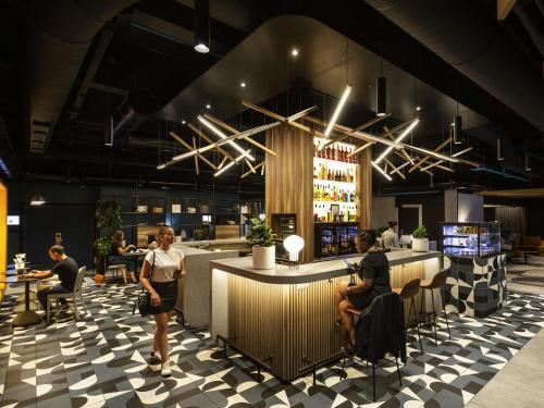 un restaurant avec des personnes assises au bar dans l'établissement Novotel Strasbourg Centre Halles, à Strasbourg