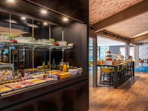 ein Restaurant mit einem Buffet mit ausgestellten Speisen in der Unterkunft Novotel Metz Amnéville in Maizières-lès-Metz