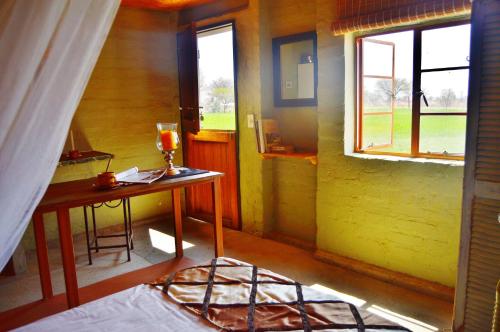 um pequeno quarto com uma mesa e uma janela em Ouhave Country Home em Imkerhof