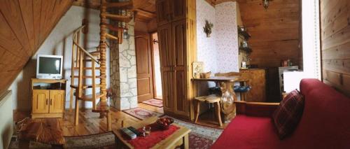 Zaovine的住宿－Konaci Zaovljanska jezera，客厅配有红色沙发和电视