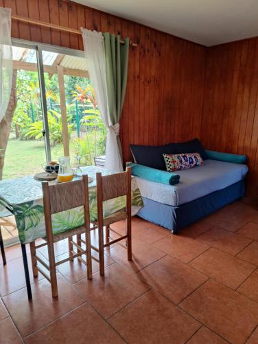 a living room with a bed and a table and chairs at Cabaña Itia in Hanga Roa