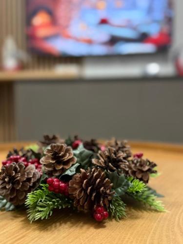 a christmas arrangement of pine cones on a table at Chic Condo at Urban in Braşov