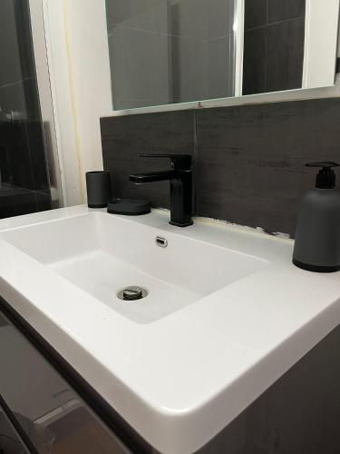 a white sink with a faucet and a mirror at Home in Cenon in Cenon