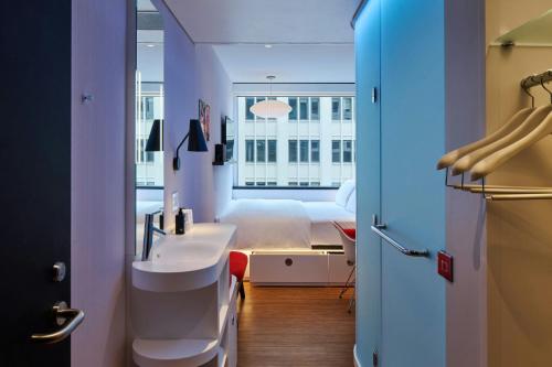 奥斯汀citizenM Austin Downtown的房间里有一间带床和洗手池的浴室