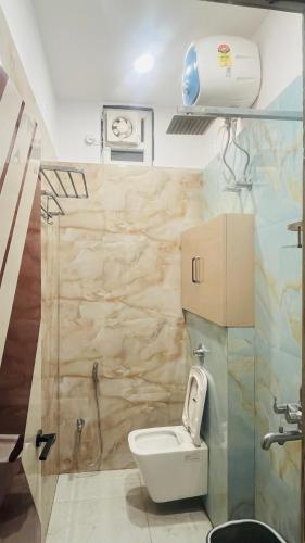 a small bathroom with a toilet and a shower at Shree LaadliJu Kothi in Deoghar