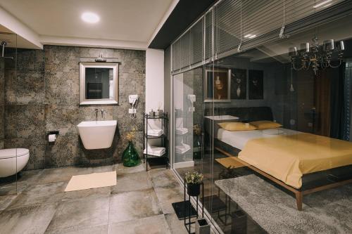 a bedroom with a bed and a bathroom with a sink at VNVP Apartment in Štip