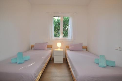 deux lits jumeaux dans une chambre avec fenêtre dans l'établissement Villa Sea and Mountain Nadal Jardi, à Alcúdia