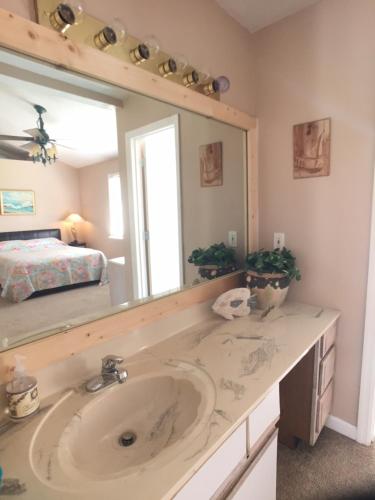 un bagno con un lavandino e un grande specchio di Fun Beach House With Pool Alligator Point a Sun N Sand Beaches