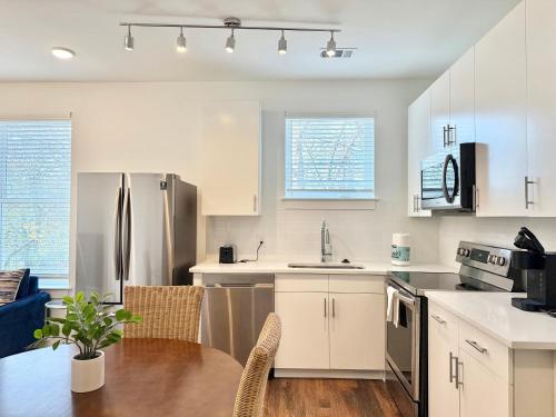 a kitchen with white cabinets and a wooden table at New 1B1B Condo in Old Fourth Ward 542Blvd207 in Atlanta