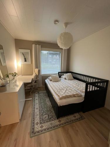 a bedroom with a bed and a desk and a window at Villa Aurora Noir in Rovaniemi